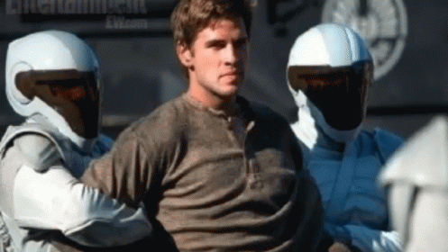 A Man In A Dirty Shirt Is Being Arrested By A Group Of Soldiers GIF