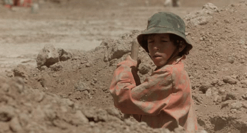 A Man In A Dirty Shirt Is Sitting On The Ground GIF