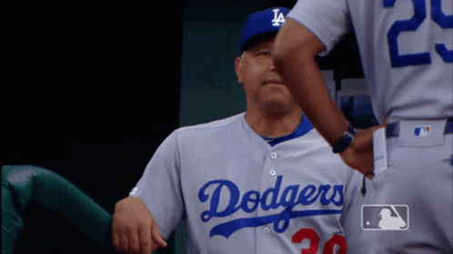 A Man In A Dodgers Jersey Is Being Hugged By Another Man GIF