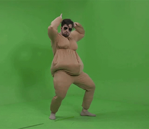 A Man In A Fat Suit Is Dancing On A Green Background GIF