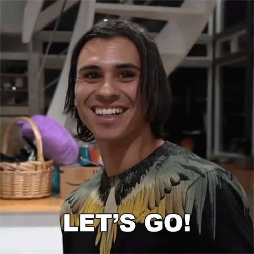 A Man In A Feathered Shirt Is Smiling And Says Let 'S Go GIF