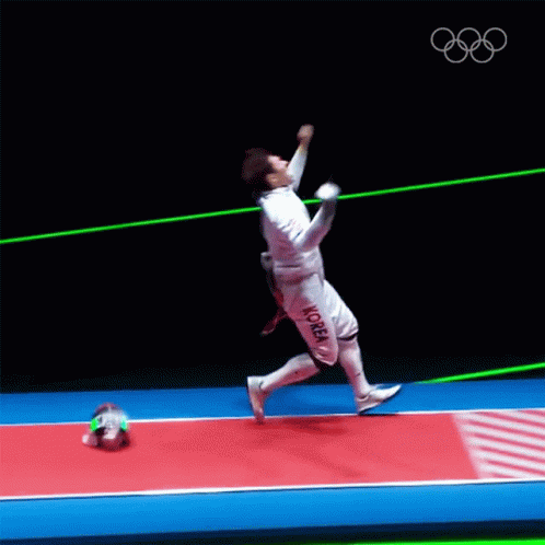 A Man In A Fencing Uniform Is Jumping In The Air With A Sword GIF