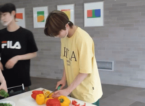 a man in a fila shirt is cutting peppers