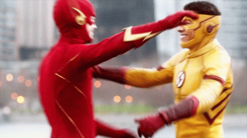A Man In A Flash Costume Is Touching Another Man 'S Face GIF