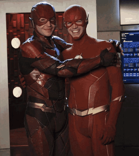 A Man In A Flash Suit Is Hugging Another Man GIF