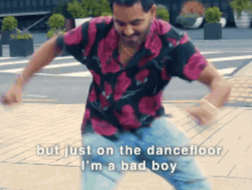 A Man In A Floral Shirt Is Dancing On The Dance Floor GIF