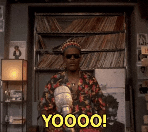 A Man In A Floral Shirt Is Standing In Front Of A Bookshelf And Says Yoooo ! GIF