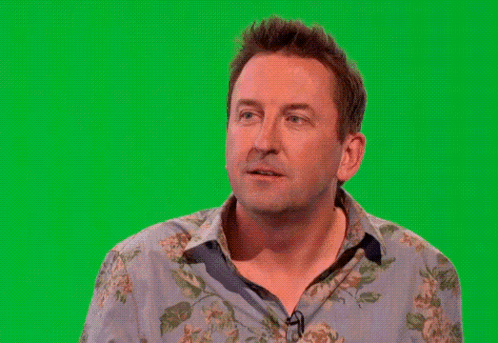 A Man In A Floral Shirt Is Waving His Hand In Front Of A Green Screen GIF