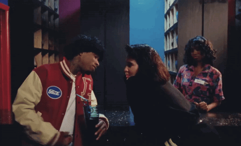 A Man In A Ford Jacket Talks To A Woman In A Pink Shirt GIF
