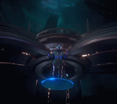 A Man In A Futuristic Costume Is Standing In A Dark Room GIF