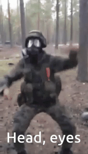 A Man In A Gas Mask Is Dancing In The Woods With The Words Head Eyes Written Below Him GIF