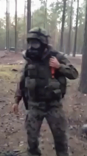 A Man In A Gas Mask Is Holding A Bottle In His Hand GIF