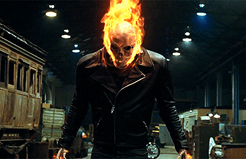 A Man In A Ghost Rider Costume Is Holding A Knife GIF