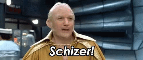 A Man In A Gold Outfit Is Saying Schizer In A Room GIF