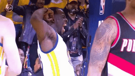 A Man In A Golden State Warriors Jersey Is Standing In Front Of A Crowd . GIF