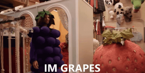 A Man In A Grape Costume Stands Next To A Giant Strawberry Costume GIF
