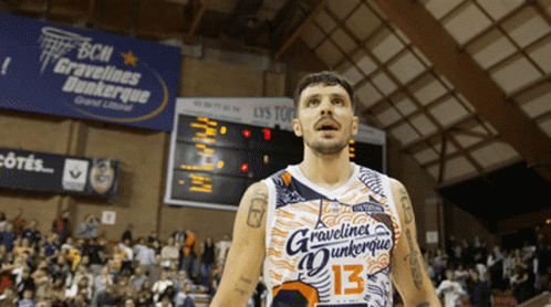 A Man In A Gravelines Dunkerque Jersey Stands In Front Of A Crowd GIF