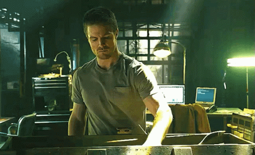 A Man In A Gray Shirt Is Standing In Front Of A Computer Monitor That Says ' Microsoft ' On It GIF