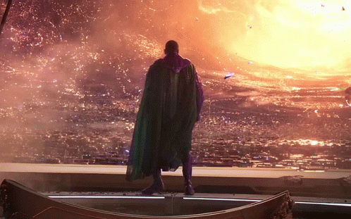 A Man In A Green Cape Is Standing In Front Of A Large Fireball GIF