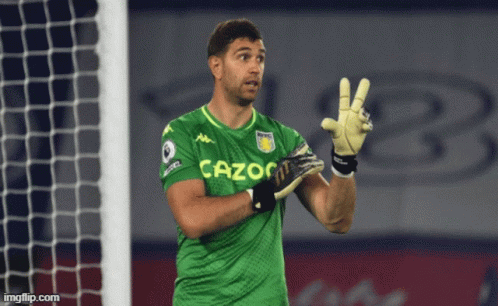 A Man In A Green Cazoo Jersey Holds Up His Gloves GIF