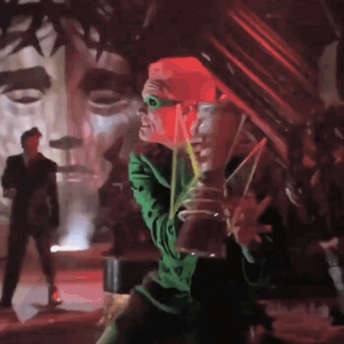 A Man In A Green Costume Is Drinking From A Glass GIF