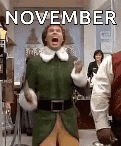 A Man In A Green Elf Costume Is Screaming In A Room With The Words `` November '' Behind Him . GIF