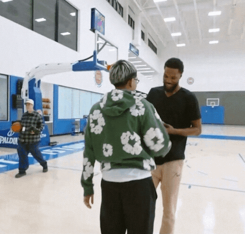a man in a green hoodie is talking to another man