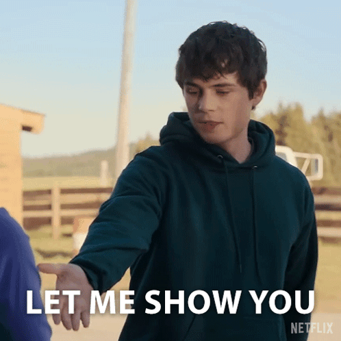 A Man In A Green Hoodie Reaches Out To Shake Someone 'S Hand And Says Let Me Show You GIF