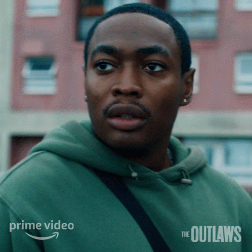 A Man In A Green Hoodie With The Outlaws On The Bottom GIF