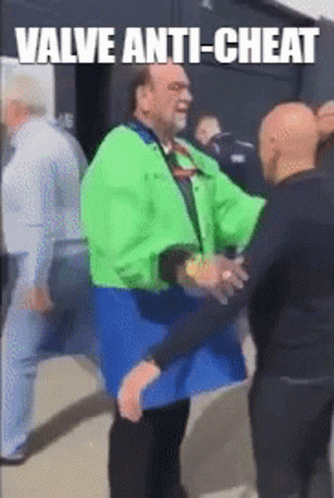 A Man In A Green Jacket Is Hugging Another Man In A Blue Jacket GIF