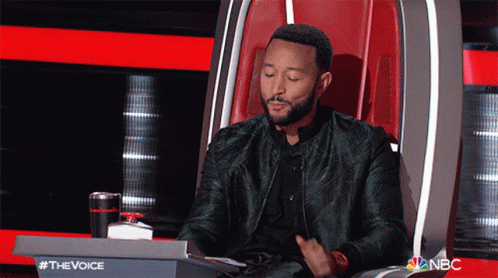 A Man In A Green Jacket Is Sitting In A Chair With A Nbc Logo In The Background GIF