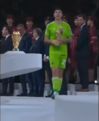 A Man In A Green Jersey With The Number 2 On It Is Holding A Trophy GIF