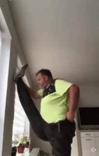 A Man In A Green Shirt Is Doing A Split GIF