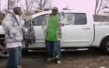 A Man In A Green Shirt Is Getting Out Of A Truck . GIF