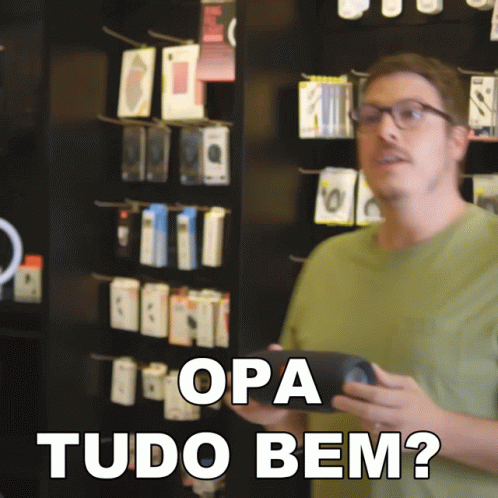 A Man In A Green Shirt Is Holding A Cell Phone And Says " Opa Tudo Bem " In White Letters GIF