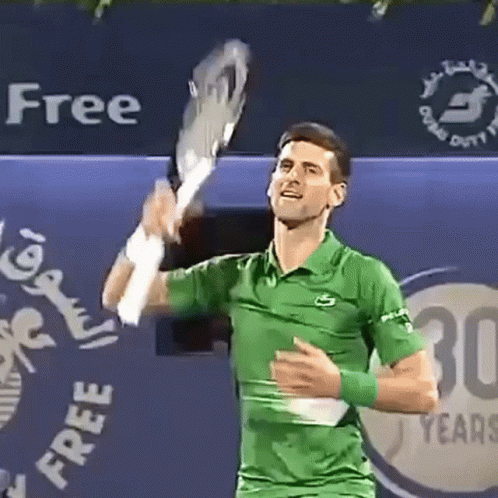 A Man In A Green Shirt Is Holding A Tennis Racquet GIF