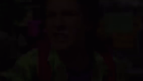 A Man In A Green Shirt Is Making A Funny Face . GIF
