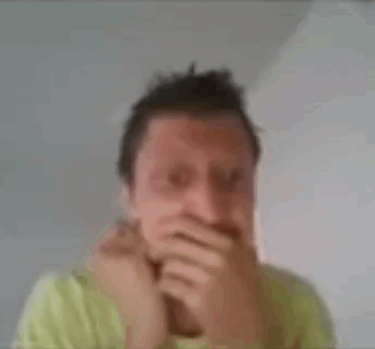 A Man In A Green Shirt Is Making A Funny Face With His Hands . GIF