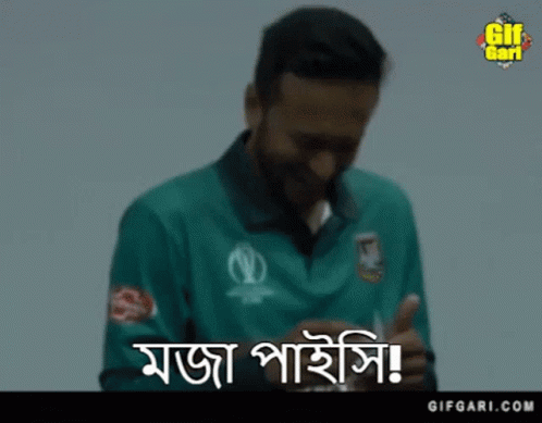 A Man In A Green Shirt Is Smiling While Holding A Card In His Hand . GIF