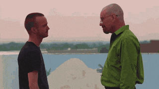 A Man In A Green Shirt Is Talking To A Man In A Black Shirt GIF