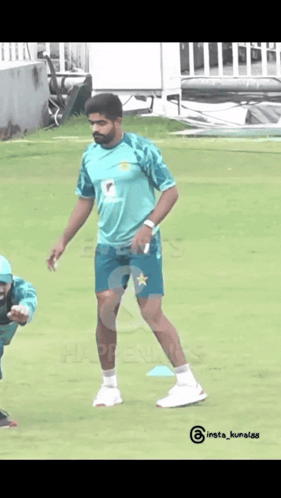 A Man In A Green Shirt With A Star On It Is Standing On A Field GIF