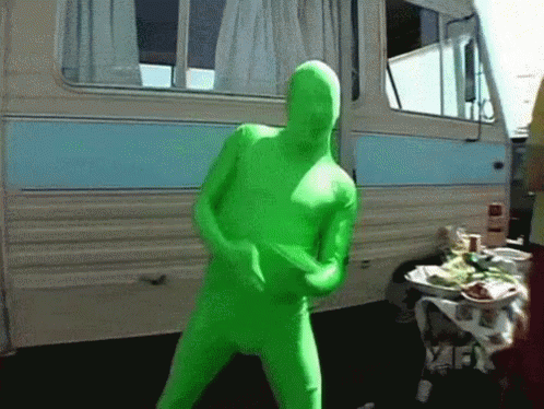 A Man In A Green Suit Is Dancing In Front Of A Camper GIF