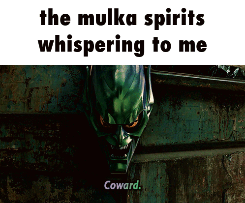 A Man In A Green Suit Is Standing In An Alleyway With The Words " The Mulka Spirits Whispering To Me " Above Him GIF