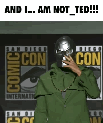 A Man In A Green Suit Is Standing In Front Of A Comic Con Sign . GIF