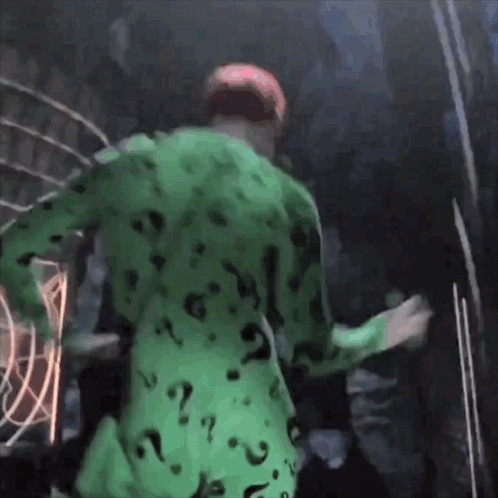 A Man In A Green Suit With Question Marks On It GIF