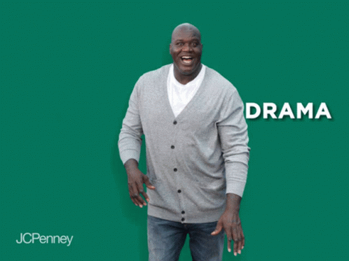 A Man In A Grey Cardigan Is Laughing In Front Of A Green Background With The Word Anxiety GIF