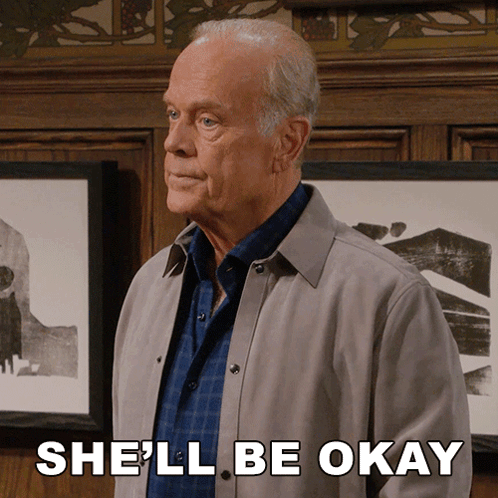 A Man In A Grey Jacket Says She 'Ll Be Okay In Front Of Framed Pictures GIF