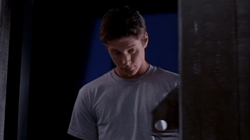 A Man In A Grey Shirt Holds A Golf Ball GIF
