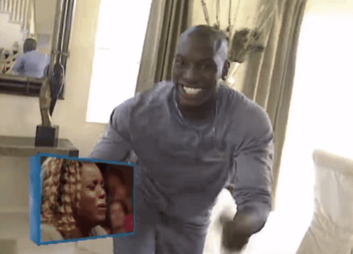 A Man In A Grey Shirt Is Holding A Picture Of A Woman GIF