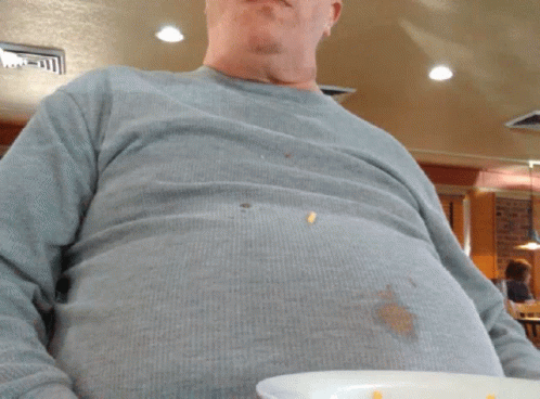 A Man In A Grey Shirt Is Holding A Plate GIF